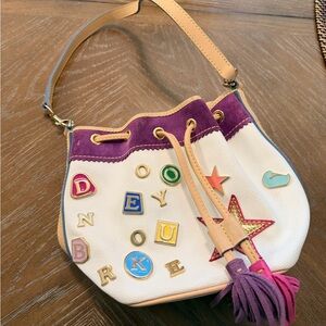 Dooney & Bourke Cream Shoulder Drawstring Bag with Purple Trim and Tan Strap